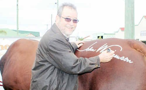 John Williamson signs John Brandon’s bull, Rocky, after the beast appeared in his Toowoomba Show performance earlier this year. John Williamson signs John Brandon’s bull, Rocky, after the beast appeared in his Toowoomba Show performance earlier this year.