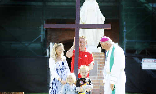 John O’Brien, assistant principal at St Carthage’s Primary School in Lismore, holds the Mary MacKillop Cross at St Carthage’s Cathedral in Lismore yesterday while the Bishop of Lismore, Geoffrey Jarrett, chats with his wife Michelle and their children Bella, 3, and Lochy, 6. Marc Stapelberg John O’Brien, assistant principal at St Carthage’s Primary School in Lismore, holds the Mary MacKillop Cross at St Carthage’s Cathedral in Lismore yesterday while the Bishop of Lismore, Geoffrey Jarrett, chats with his wife Michelle and their children Bella, 3, and Lochy, 6. Marc Stapelberg