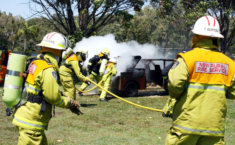 PICTURED are firefighters hosing the burning ‘car’ and (left) carrying the ‘injured person’ to safety. PICTURED are firefighters hosing the burning ‘car’ and (left) carrying the ‘injured person’ to safety.