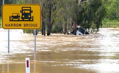 A man clings to his vehicle yesterday after it was washed downstream from the Isaac River Bridge on Monday night. A man clings to his vehicle yesterday after it was washed downstream from the Isaac River Bridge on Monday night.