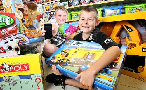 Caleb and Ethan Oberg show off the latest trends in Christmas gifts. Retailers say there is a move towards more traditional gifts such as Lego and board games for younger kids, while the older ones are going for iPhones and iPads. Caleb and Ethan Oberg show off the latest trends in Christmas gifts. Retailers say there is a move towards more traditional gifts such as Lego and board games for younger kids, while the older ones are going for iPhones and iPads.