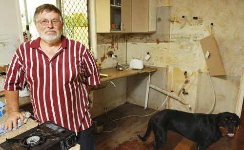 Stuart Steenstra with his dog Jayda in the kitchen of his flood-damaged home. Stuart Steenstra with his dog Jayda in the kitchen of his flood-damaged home.