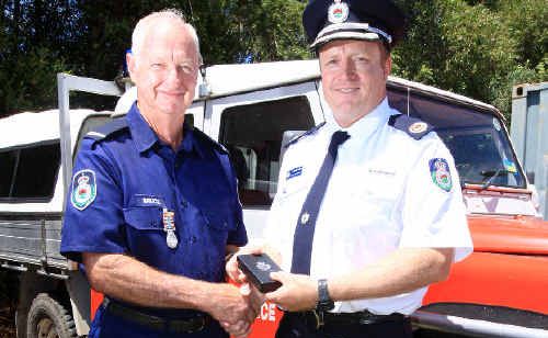 Tyalgum deputy captain Bruce Bartrim is presented with a long-service medal from Assistant Commissioner Dominic Lane, and (inset) award recipient group captain Mark Eglington (centre) with proud relatives. Tyalgum deputy captain Bruce Bartrim is presented with a long-service medal from Assistant Commissioner Dominic Lane, and (inset) award recipient group captain Mark Eglington (centre) with proud relatives.