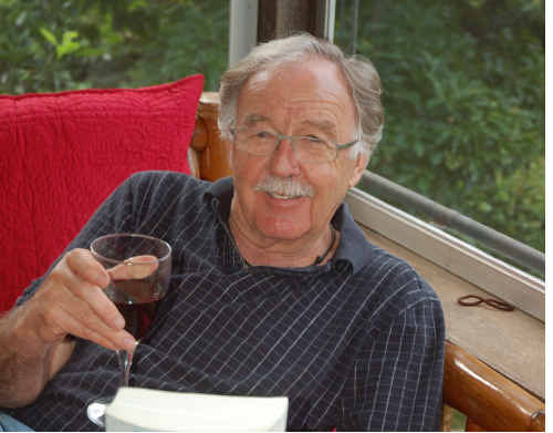 George Negus enjoys a glass of red and a good read at his Bellingen home. 