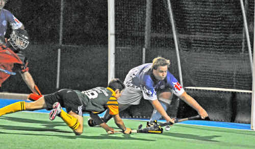 A City Bears player sneaks one past a Sailors defender on Sunday night in Round 1 of the A-grade men’s hockey. A City Bears player sneaks one past a Sailors defender on Sunday night in Round 1 of the A-grade men’s hockey.