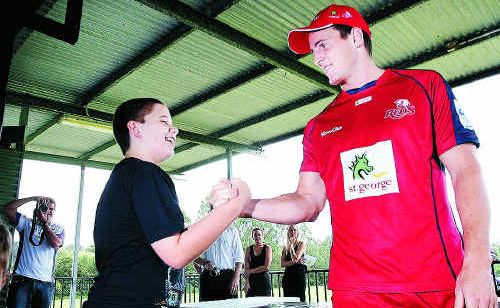 Queensland Reds player Mike Harris chats with a local youngster at the Lions Rugby Union Club in Karana Downs yesterday. Queensland Reds player Mike Harris chats with a local youngster at the Lions Rugby Union Club in Karana Downs yesterday.