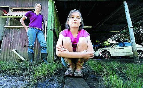 Felicity Jenkins, eight, and her brothers cannot play in their Mount Morgan yard because it has become a swamp and her mother Emma Jenkins has to walk along a plank to get to the laundry. Felicity Jenkins, eight, and her brothers cannot play in their Mount Morgan yard because it has become a swamp and her mother Emma Jenkins has to walk along a plank to get to the laundry.