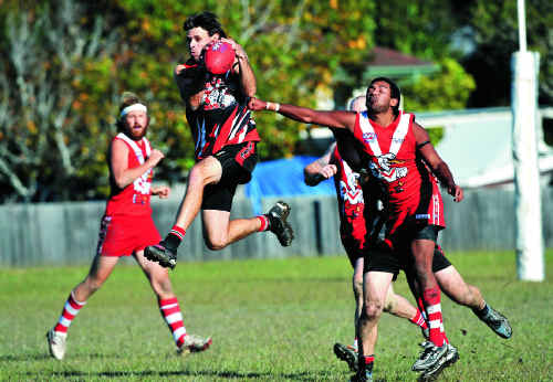 Sawtell’s Daniel Pritchard spoils as Coffs Swans rival Jason Sincock attempts to mark.