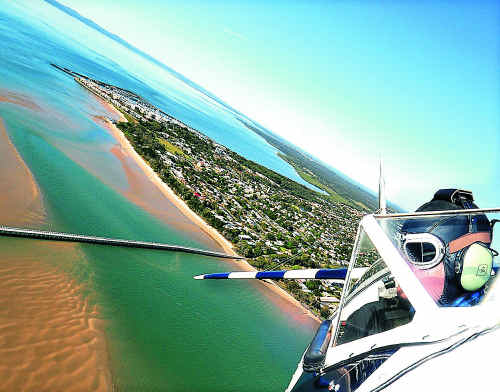 Pilot Tim Berry steers his 1941 Boeing Stearman biplane over the Urangan Pier on Saturday morning. Pilot Tim Berry steers his 1941 Boeing Stearman biplane over the Urangan Pier on Saturday morning.