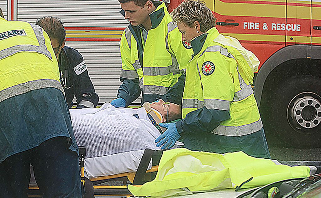 Emergency services personnel treat a man at the scene of an accident near the Tugun Bypass. Emergency services personnel treat a man at the scene of an accident near the Tugun Bypass.