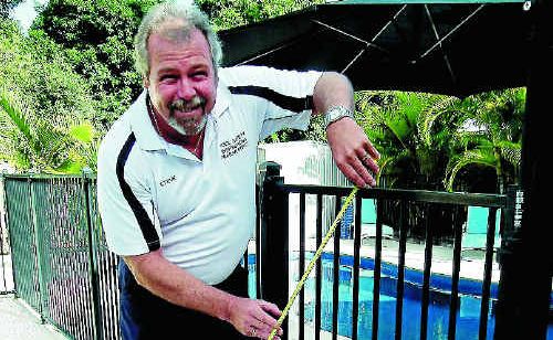 Pool safety inspector Steve Anderson checks the additional clear area on a family swimming pool.