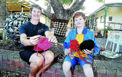 Annie Hackett, of Georgie’s Cafe, and 10-year-old Samuel Page with some of the knit-wear for the Clarence Valley guerrilla knitting project. Photo: JOJO NEWBY Annie Hackett, of Georgie’s Cafe, and 10-year-old Samuel Page with some of the knit-wear for the Clarence Valley guerrilla knitting project. Photo: JOJO NEWBY
