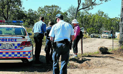 Police officers inspect a property after a man was arrested following a siege in Tannum Sands on Tuesday night. Police officers inspect a property after a man was arrested following a siege in Tannum Sands on Tuesday night.