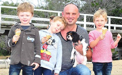 Astin, Bayer, dad Gareth and Tanner with Mischa the puppy at the sand garden display yesterday. Astin, Bayer, dad Gareth and Tanner with Mischa the puppy at the sand garden display yesterday.