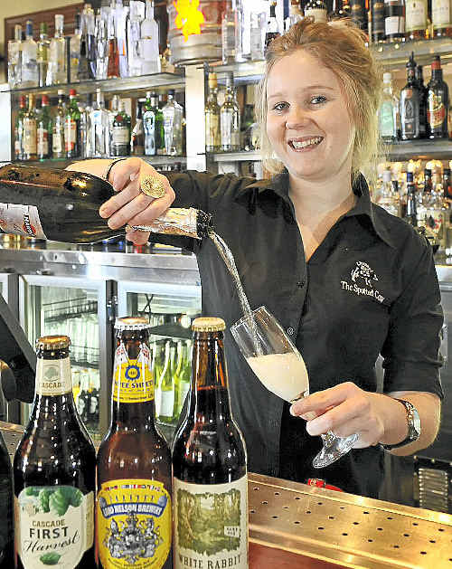 Bartender Caitlin Campbell shows off the pub’s beer variety and the now popular white wine. Bartender Caitlin Campbell shows off the pub’s beer variety and the now popular white wine.