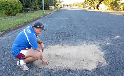 Steve Sammut inspects the work done to fill a potentially dangerous sinkhole in front of his Dennis Street home in South Mackay yesterday.