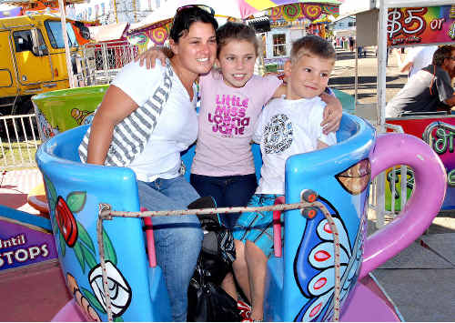 Elisha Marion, of Yeppoon, shares a ride with her children, Lucy and Jett, at Mackay Show yesterday.