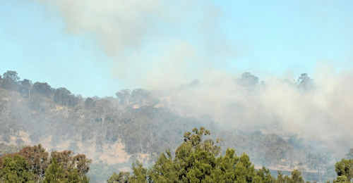 Clouds of smoke billow up from the hills on Connolly Dam Rd and (inset) the burned remains of a Granite Belt home. Clouds of smoke billow up from the hills on Connolly Dam Rd and (inset) the burned remains of a Granite Belt home.