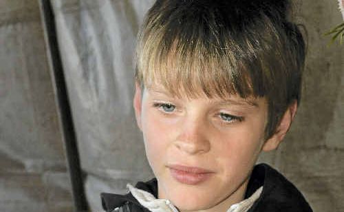 Josiah Eddison, 10, lights a candle in memory of flood victims at the Murphys Creek six-month remembrance service. Josiah Eddison, 10, lights a candle in memory of flood victims at the Murphys Creek six-month remembrance service.