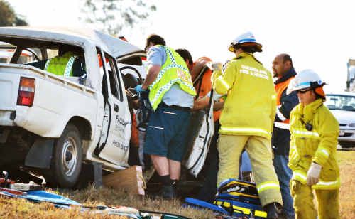 Emergency services workers at the scene of the crash east of Roma. Emergency services workers at the scene of the crash east of Roma.