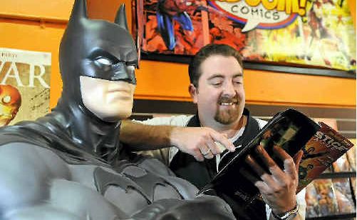 Kaboom comic bookshop owner Todd Baillie flicks through the new Justice League America comic with Batman. Kaboom comic bookshop owner Todd Baillie flicks through the new Justice League America comic with Batman.