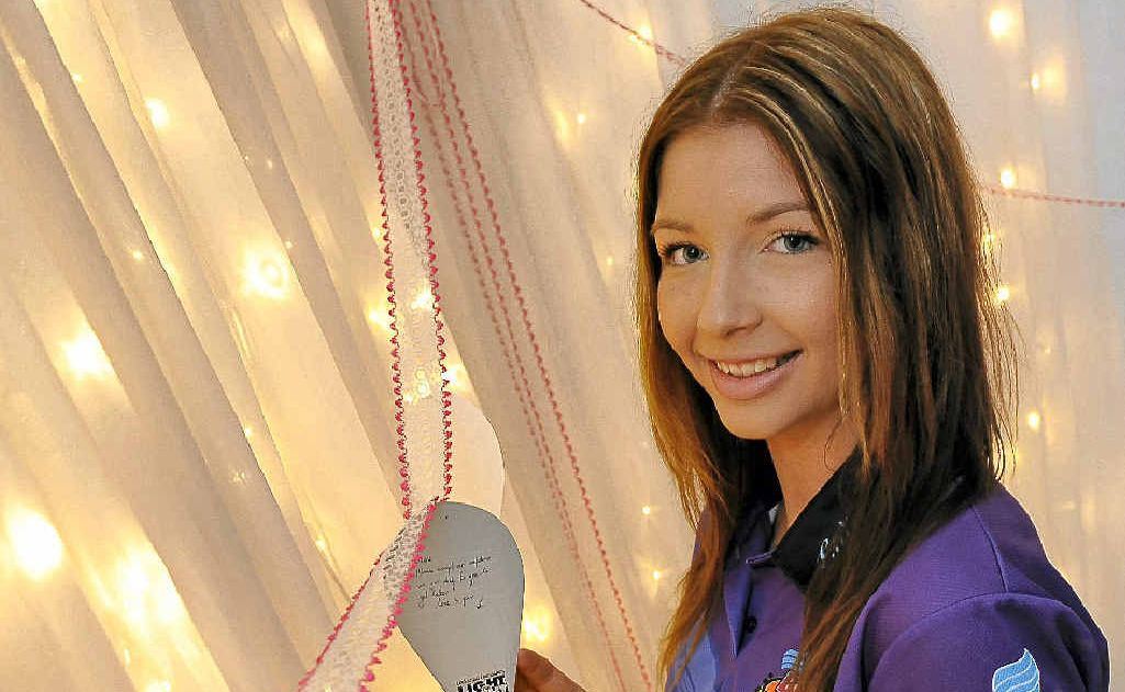 Wide Bay Australia Bundy Thunder Quest entrant Morgan Wagstaff places a lantern on the message wall at the Light the Night event at Nielson Park, Bargara. Wide Bay Australia Bundy Thunder Quest entrant Morgan Wagstaff places a lantern on the message wall at the Light the Night event at Nielson Park, Bargara.