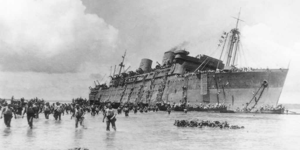 Troops wade ashore from the President Coolidge as she remains upright. Troops wade ashore from the President Coolidge as she remains upright.