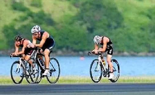 Triathletes ride across the airport runway during last year’s Hamilton Island Triathlon. Triathletes ride across the airport runway during last year’s Hamilton Island Triathlon.