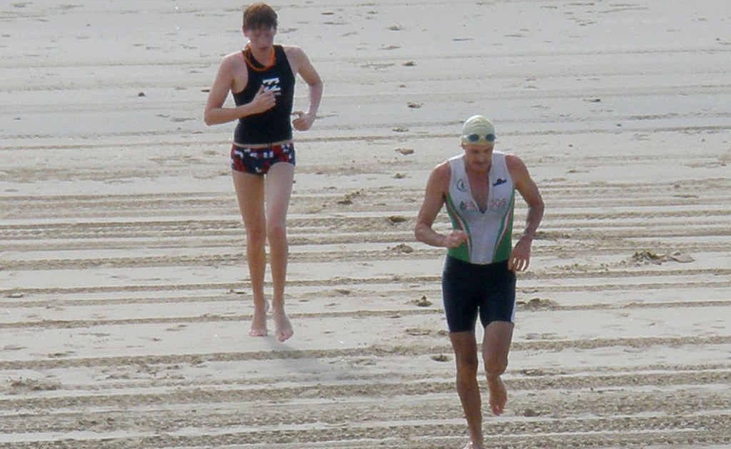 Peter O’Shaughnessy leads Harley Messersmith out of the water after the swim leg in the triathlon at the Mercure Capricorn Resort. Peter O’Shaughnessy leads Harley Messersmith out of the water after the swim leg in the triathlon at the Mercure Capricorn Resort.