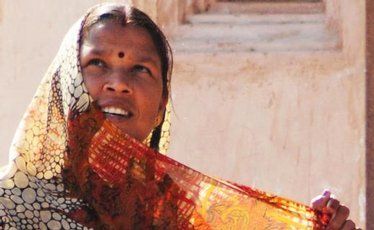 A woman adjusts her sari in the sun. A woman adjusts her sari in the sun.