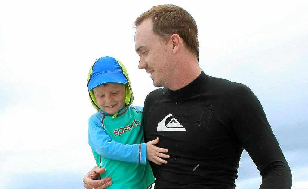 Harry and Dad Ashley Radbourne enjoy the waves at Rainbow Bay.