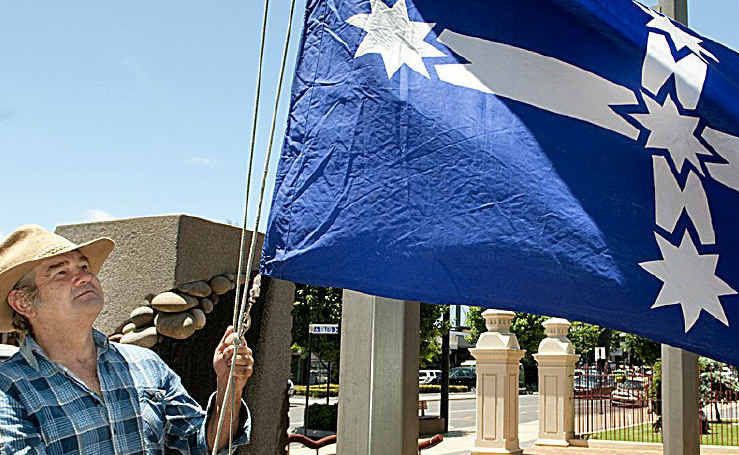 Paul King raises the Eureka flag at the Village Green.