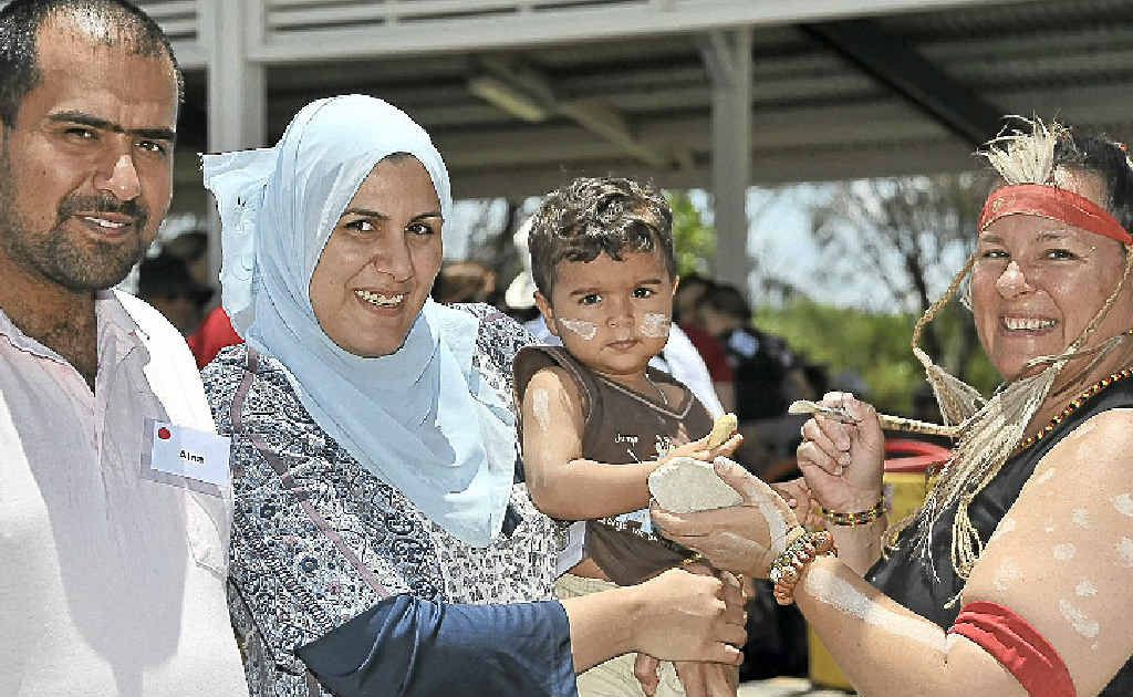 Iraqi refugees Alaa and Shaymaa Al-Fatlawee and their son Mobasher, 1, with local Aboriginal dancer, Paula Wootton. Iraqi refugees Alaa and Shaymaa Al-Fatlawee and their son Mobasher, 1, with local Aboriginal dancer, Paula Wootton.