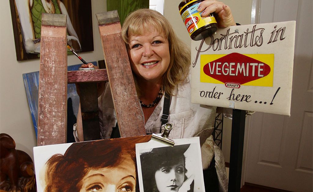 Julie Gould with one of her paintings created with Vegemite. Julie Gould with one of her paintings created with Vegemite.