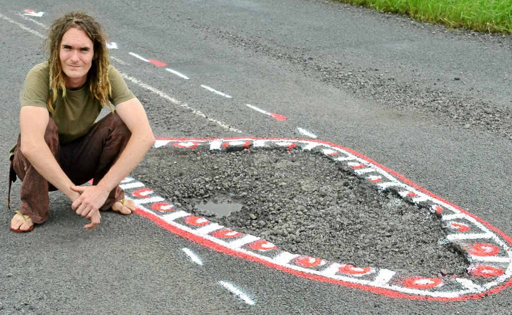 Aaron Gibbs of Lismore pictured on Nimbin Rd at Goolmangar with the pothole that caused more than $3000 of damage to his father's car. Aaron Gibbs of Lismore pictured on Nimbin Rd at Goolmangar with the pothole that caused more than $3000 of damage to his father's car.