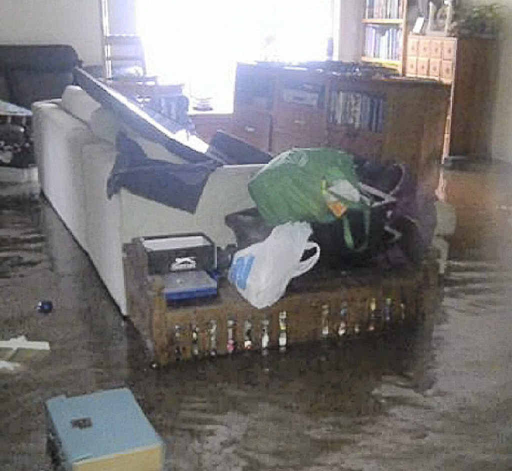 Furniture floats around as floodwaters enter a home at Corindi. 