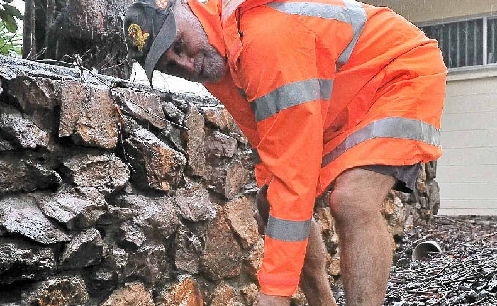 Acting Maroochydore group SES leader David Williams digs a trench to stop the SES building at Buderim from being flooded.