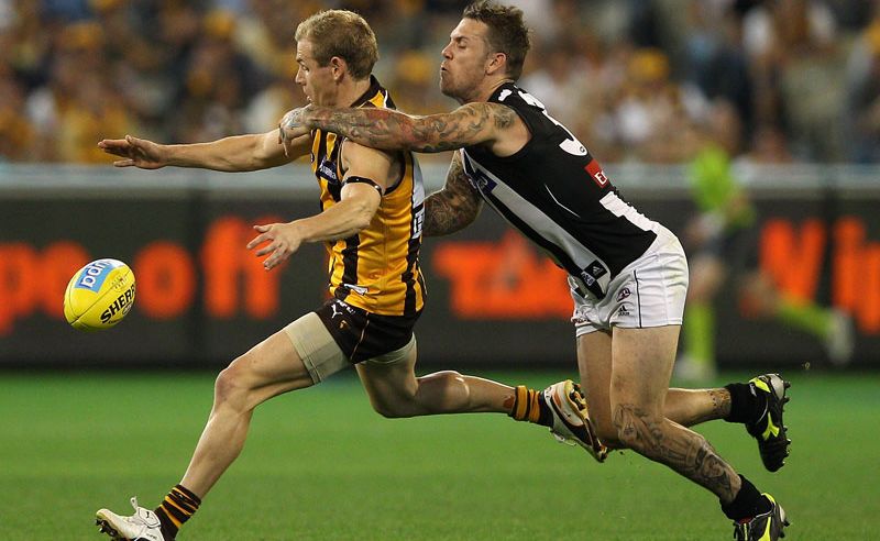 Michael Osborne of the Hawks kicks whilst being tackled by Dane Swan of the Magpies during the round one AFL match between the Hawthorn Hawks and the Collingwood Magpies at the Melbourne Cricket Ground Michael Osborne of the Hawks kicks whilst being tackled by Dane Swan of the Magpies during the round one AFL match between the Hawthorn Hawks and the Collingwood Magpies at the Melbourne Cricket Ground