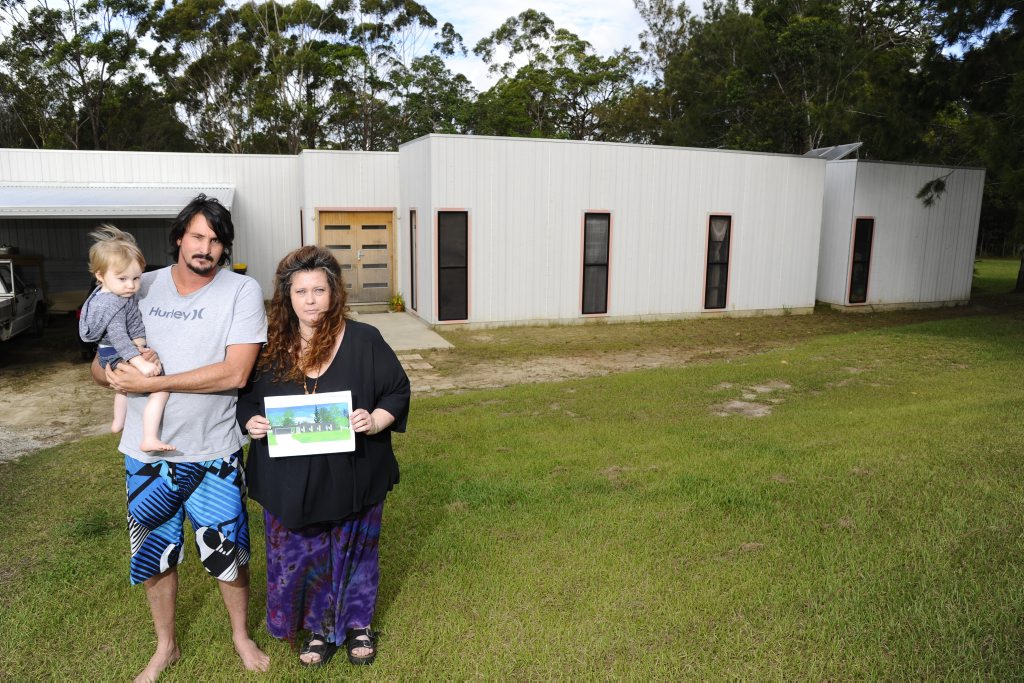 Charlie, Justin and Kelly Clark, stand in front of their house, which was constructed by GJ Garnder Homes. Kelly holds the plans for the outside of their 