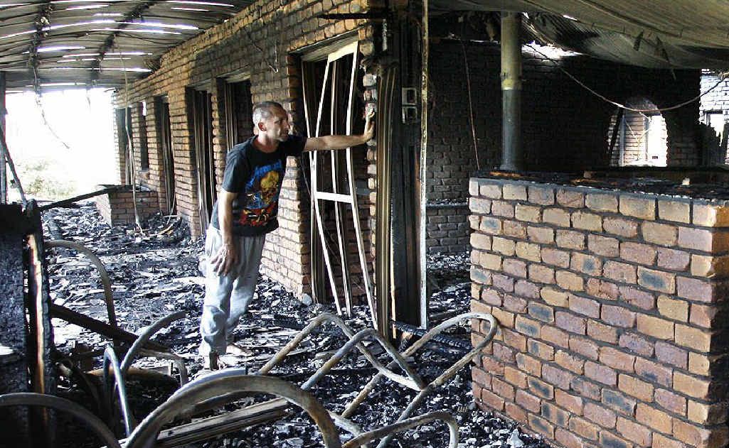 Brenden Reynolds surveys the wreckage of his father’s burnt-out home. Brenden Reynolds surveys the wreckage of his father’s burnt-out home.