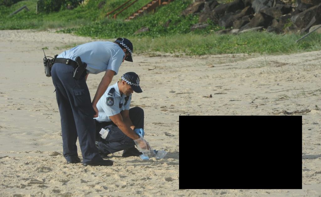 Police on the beach at Palm Beach with the man's body. Police on the beach at Palm Beach with the man's body.