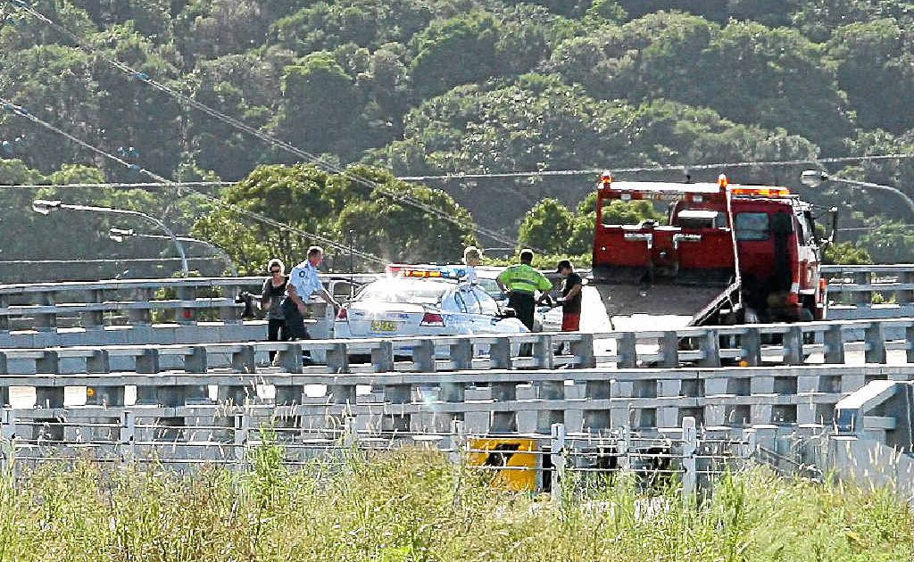 Police officers and a tow truck driver assisting motorists who were hit during a high-speed chase south of Ballina yesterday afternoon. Police officers and a tow truck driver assisting motorists who were hit during a high-speed chase south of Ballina yesterday afternoon.