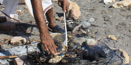 A fisherman cooks lunch on the beach in the Omani port town of Quriyat.
A fisherman cooks lunch on the beach in the Omani port town of Quriyat.