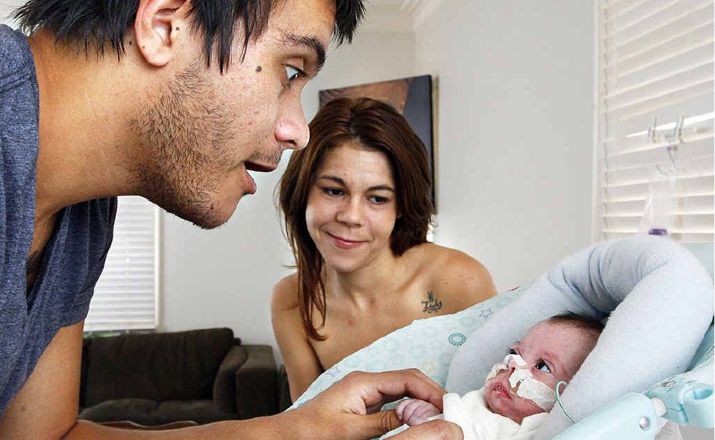 Jarren Shapcott and Danielle Bond play with their little miracle, Peyton Serenity-Lee Shapcott, who was born nine weeks premature by the roadside in Silkstone. Jarren Shapcott and Danielle Bond play with their little miracle, Peyton Serenity-Lee Shapcott, who was born nine weeks premature by the roadside in Silkstone.
