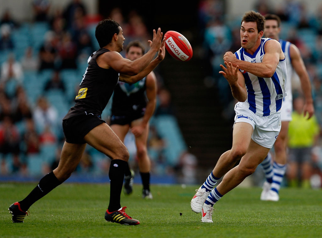Danyle Pearce of the Power blocks while Levi Greenwood of the Kangaroos handpasses during the round eight AFL match between Port Adelaide Power and North Melbourne Kangaroos at AAMI Stadium 