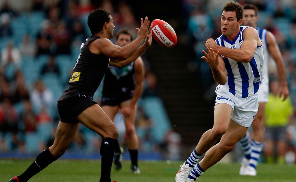 Danyle Pearce of the Power blocks while Levi Greenwood of the Kangaroos handpasses during the round eight AFL match between Port Adelaide Power and North Melbourne Kangaroos at AAMI Stadium Danyle Pearce of the Power blocks while Levi Greenwood of the Kangaroos handpasses during the round eight AFL match between Port Adelaide Power and North Melbourne Kangaroos at AAMI Stadium