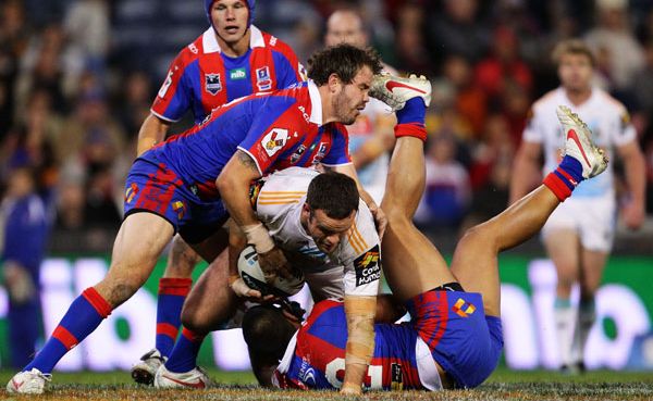 Nate Myles of the Titans is tackled during the round 12 NRL match between the Newcastle Knights and the Gold Coast Titans at Hunter Stadium. Nate Myles of the Titans is tackled during the round 12 NRL match between the Newcastle Knights and the Gold Coast Titans at Hunter Stadium.
