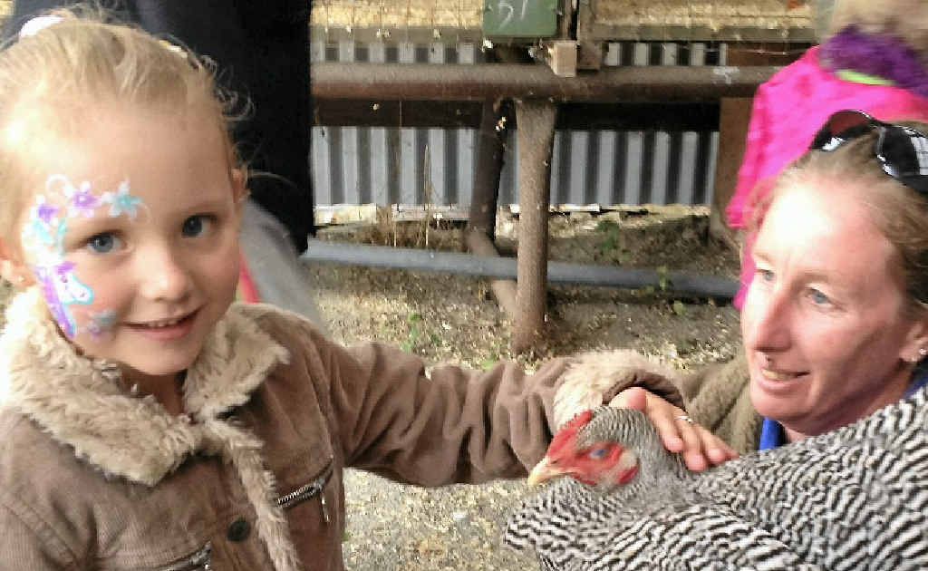 Brianna Ward, 5, pats a chook held by Kylie Nixon. Brianna Ward, 5, pats a chook held by Kylie Nixon.