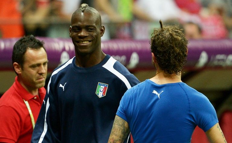 Mario Balotelli of Italy smiles as he celebrates victory after the UEFA EURO 2012 semi final match between Germany and Italy. Mario Balotelli of Italy smiles as he celebrates victory after the UEFA EURO 2012 semi final match between Germany and Italy.