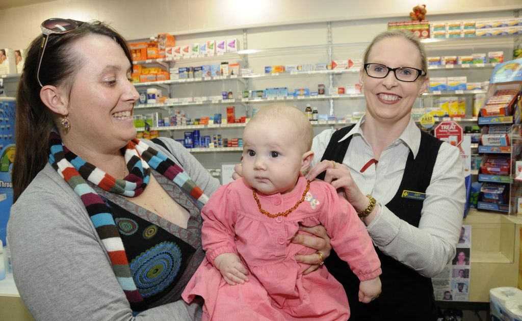 Five-month-old Sarah Hunt tries on an amber teething necklace as mum Jodie Hunt (left) and Judy Wielandt from Southtown Pharmacy look on. Five-month-old Sarah Hunt tries on an amber teething necklace as mum Jodie Hunt (left) and Judy Wielandt from Southtown Pharmacy look on.